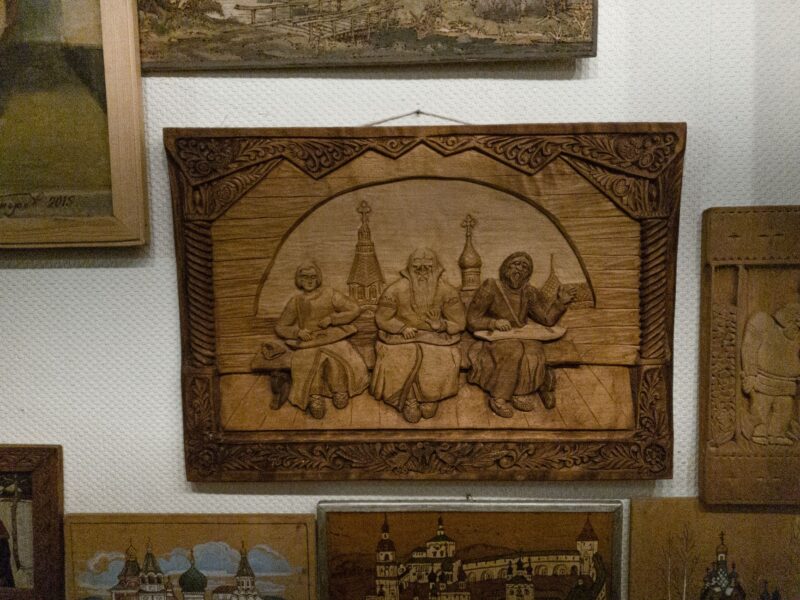 Detailed bas relief artwork on display in a museum, showcasing wood craftsmanship.