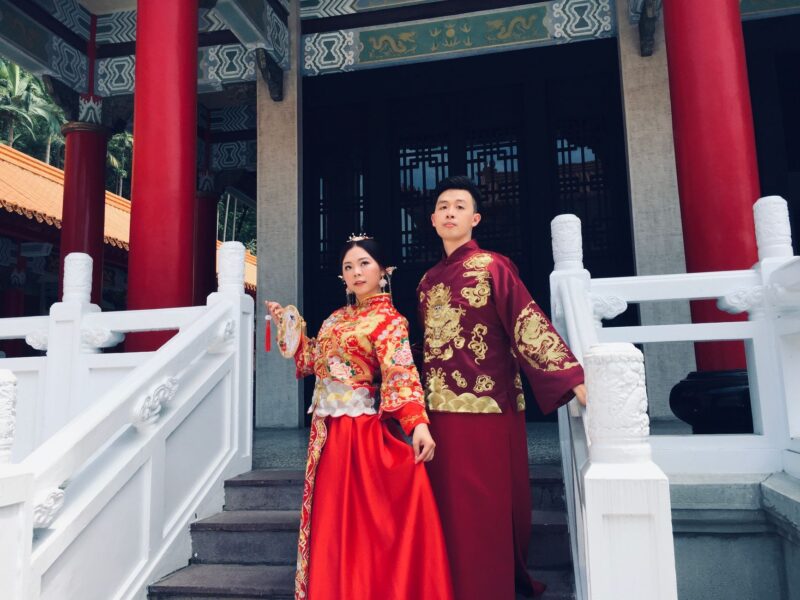 Elegant couple in traditional Chinese wedding costumes at a temple in Ji Lin Sheng, China.